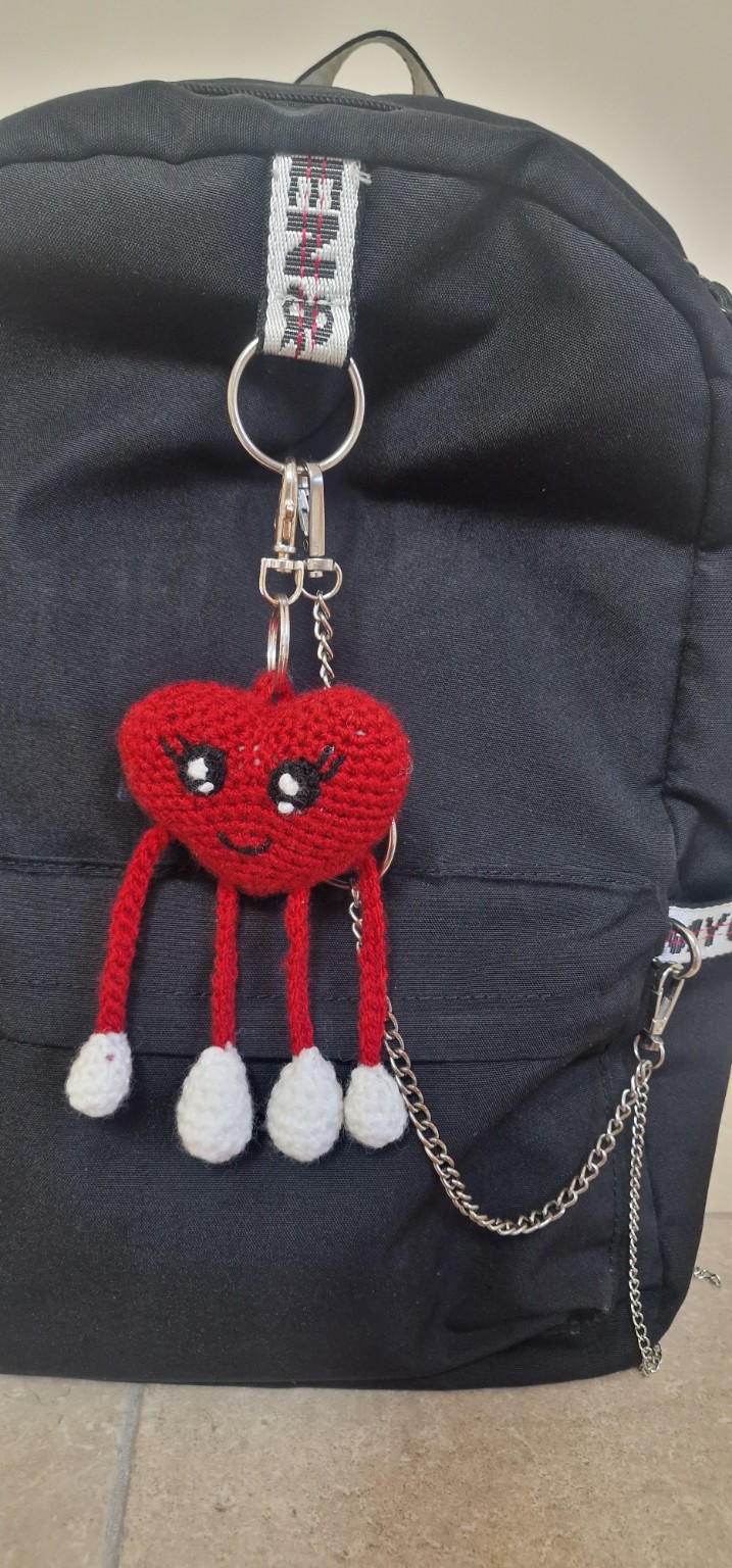 Handmade crochet heart keychain attached to backpack
