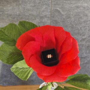 Handcrafted crepe paper rose with realistic green leaves